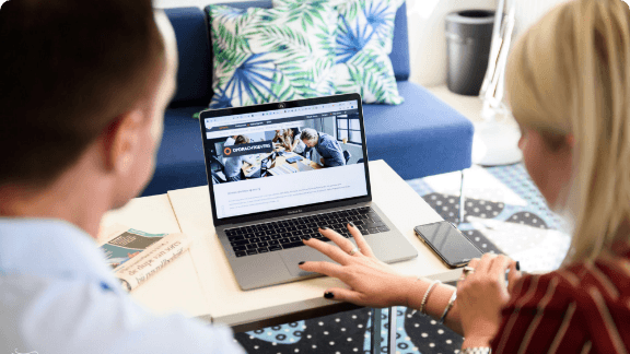 Twee collega's kijken naar een laptopscherm Twee collega's kijken naar een laptopscherm